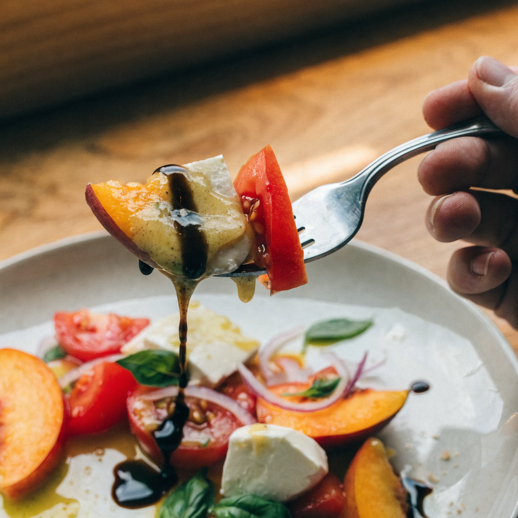 Close-up of peach tomato caprese salad with lemon-basil pesto vinaigrette